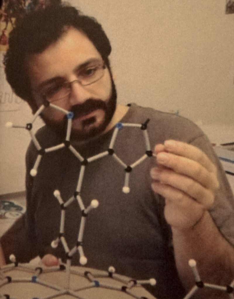 A photograph of Alessandro Sorrenti working with a molecular modelling kit